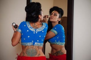 girl in sari putting on makeup