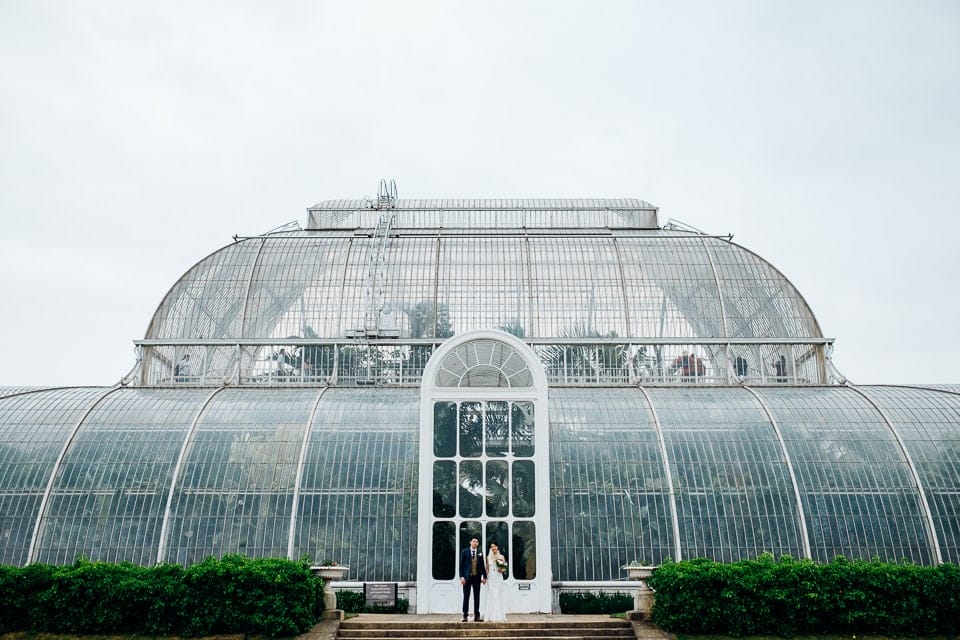 bride and groom outside palm house in kew gardens