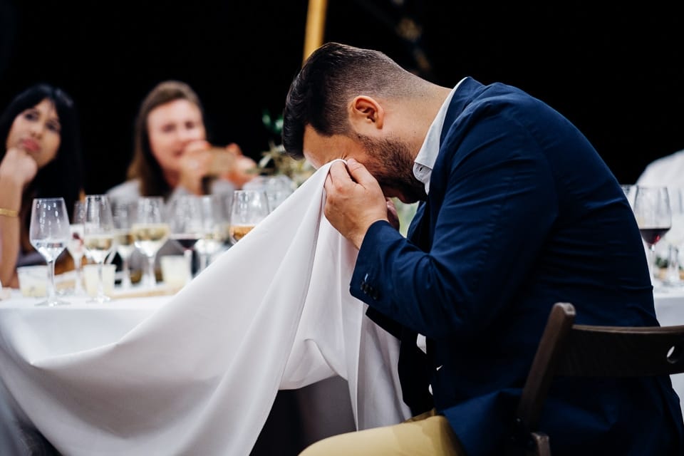 man crying into table cloth